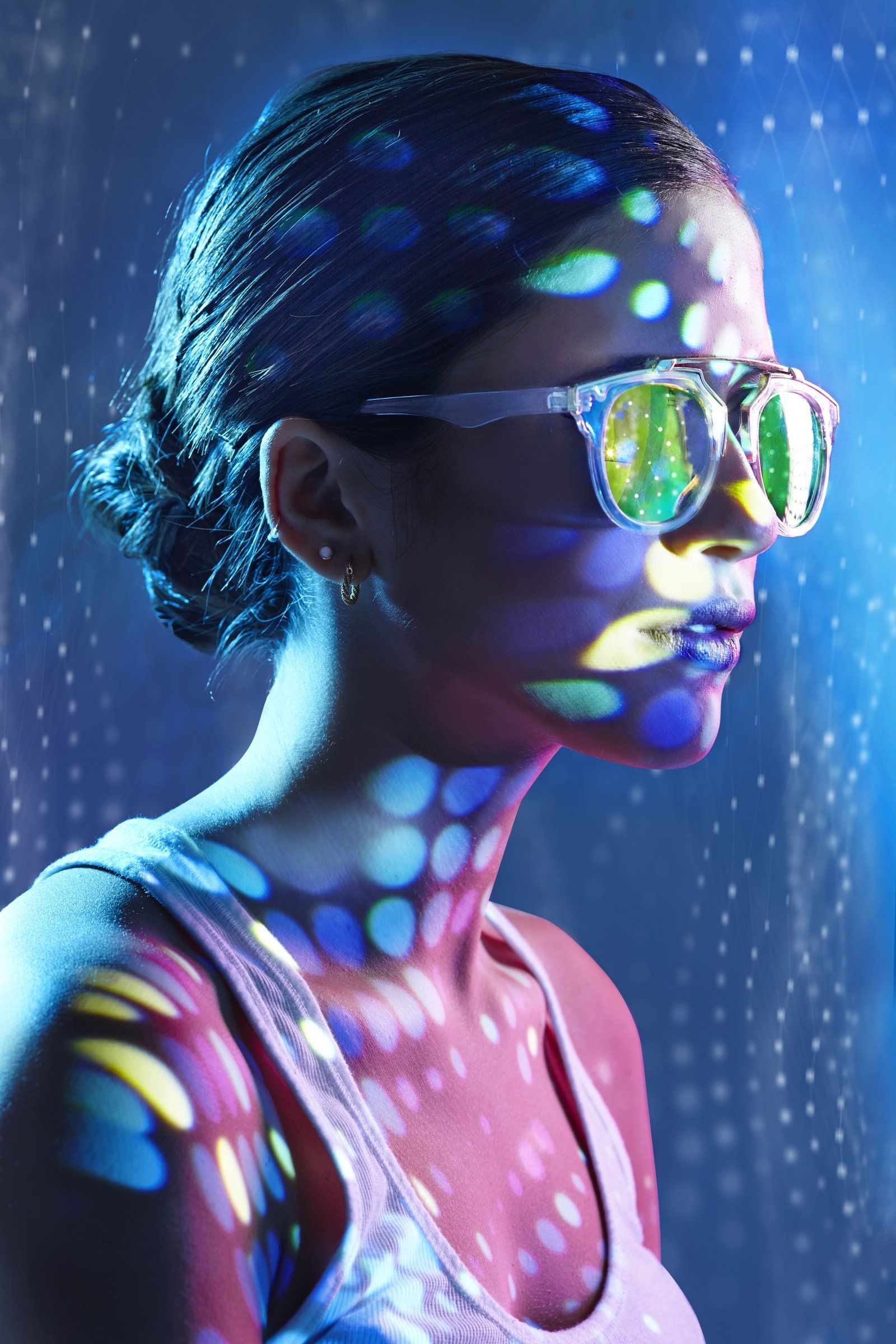 Model with neon light projected on her skin, from a beauty shoot